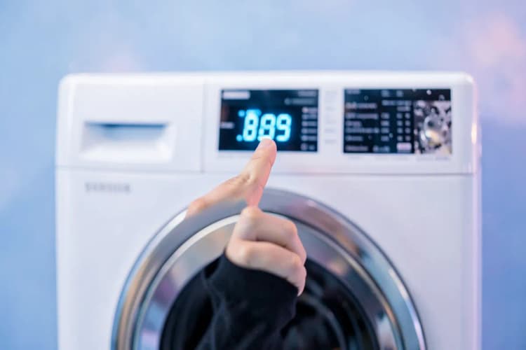 Mão humana apontando para um código de erro em um painel digital de lava e seca Samsung.